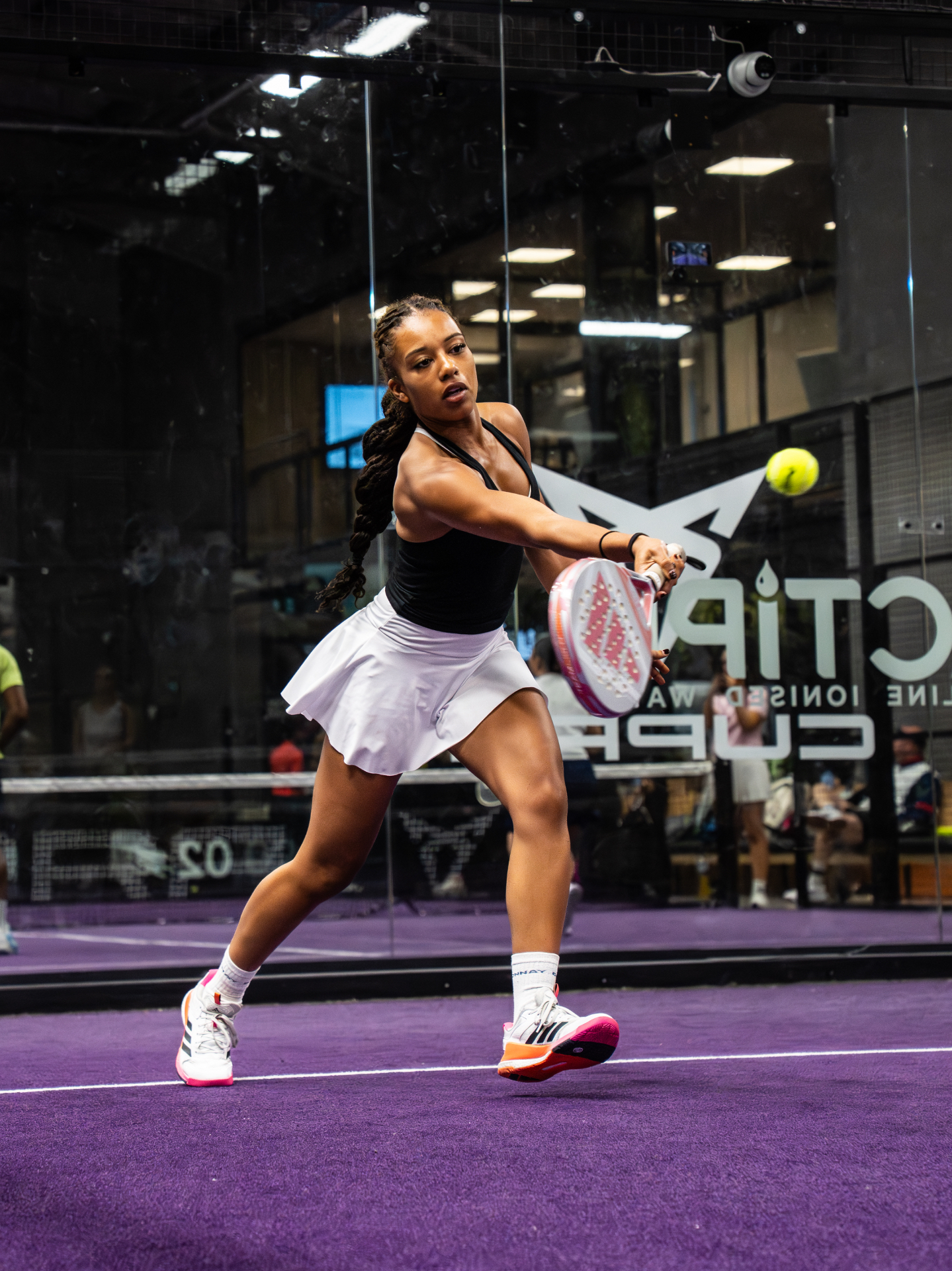 Player driving a backhand during a competitive padel rally