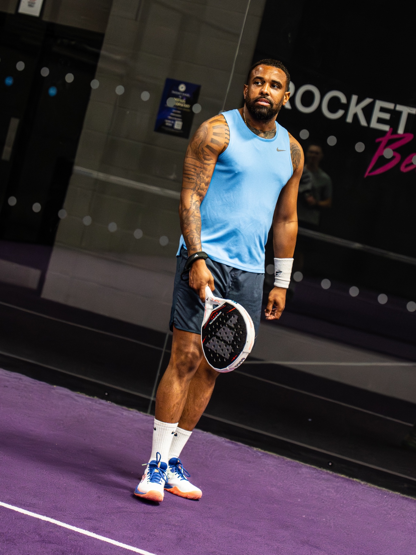 Player waiting between points on the purple court
